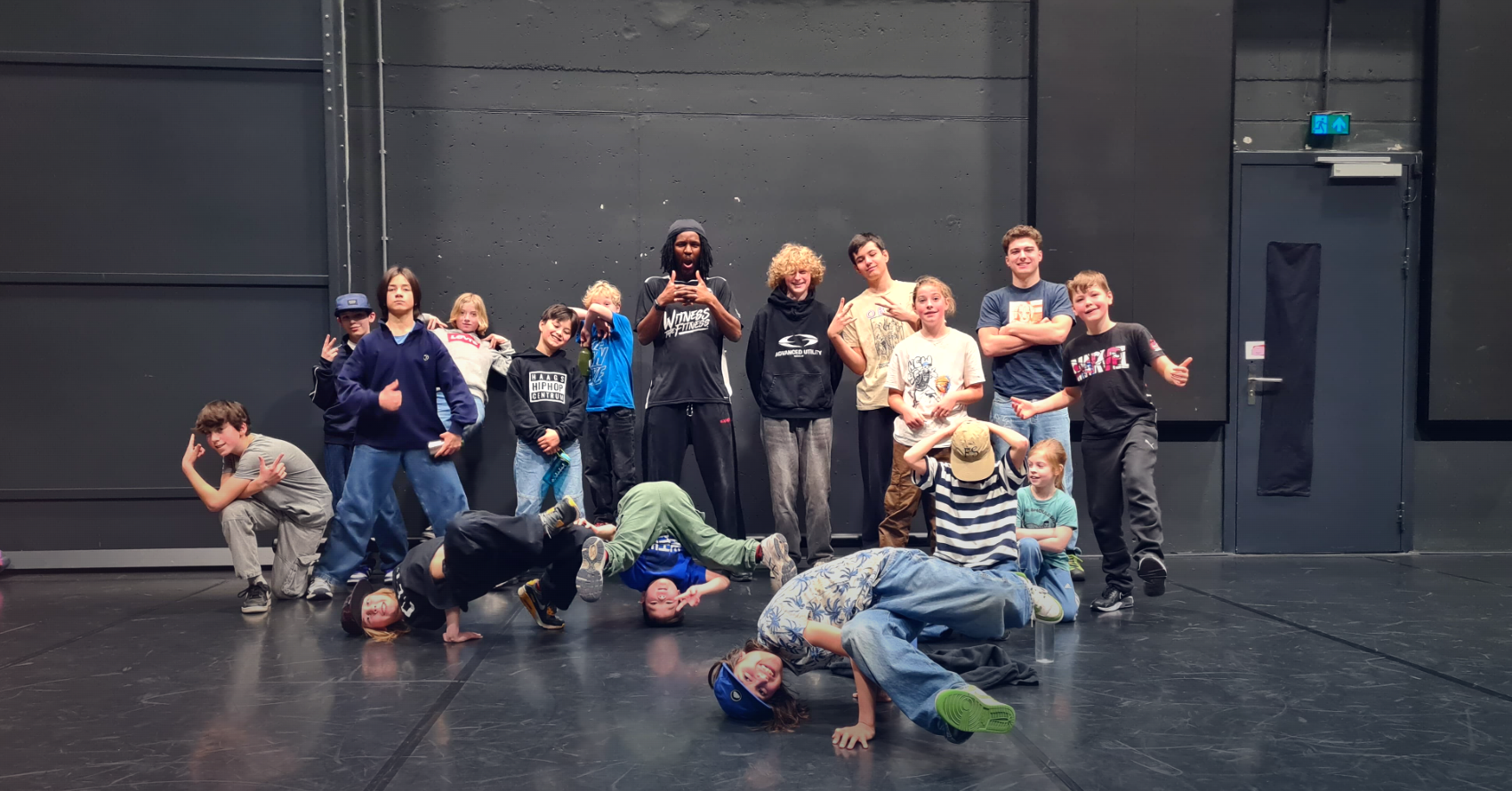 Hiphop- en breakdanceles van Happyflex: een groep kinderen en een vakdocent in een dansstudio, een paar leerlingen breakdancen op de vloer